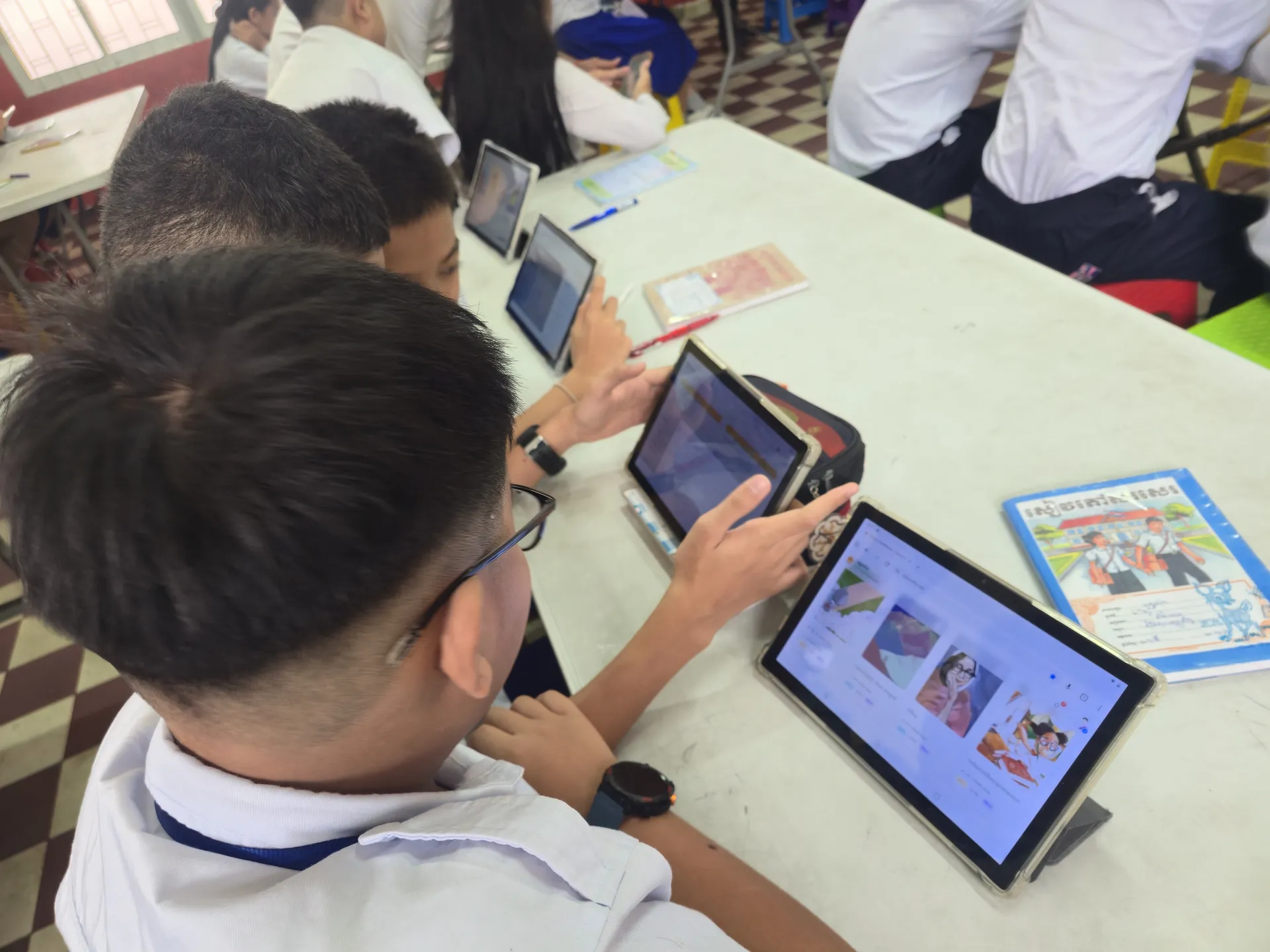 A student browsing book covers in the PLP catalogue on a tablet.
