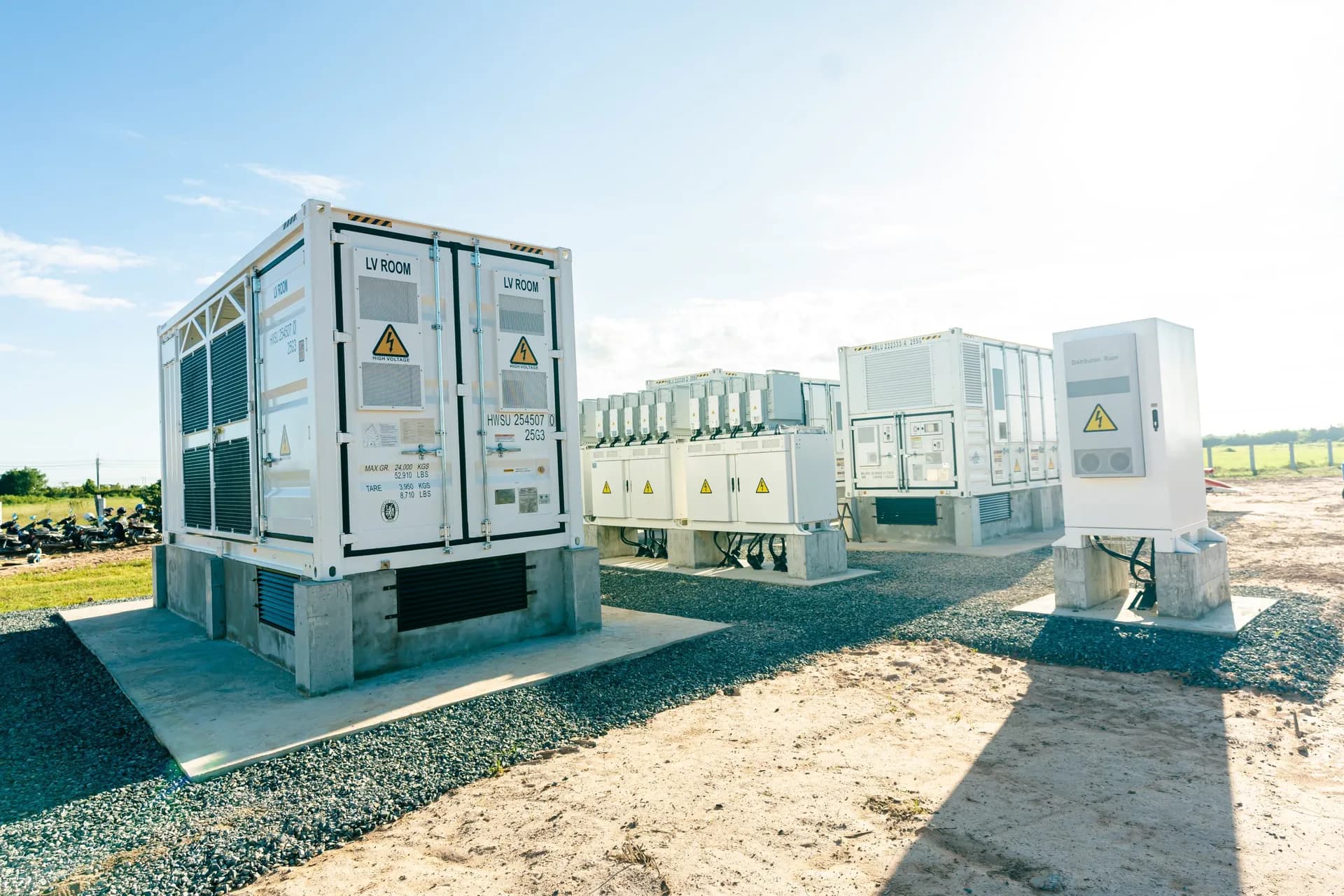 Inverter and storage containers standing in the field at a SchneiTec solar plant.